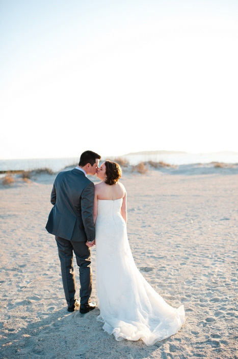 bride and groom kissing on the beach