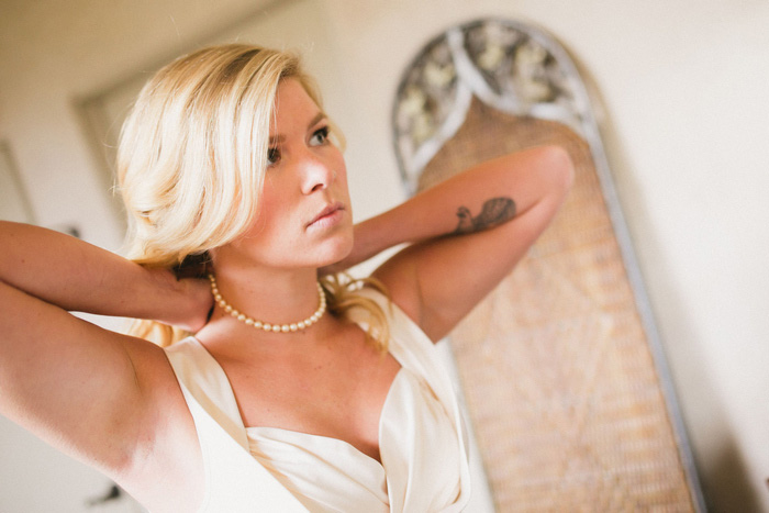 bride putting on her necklace