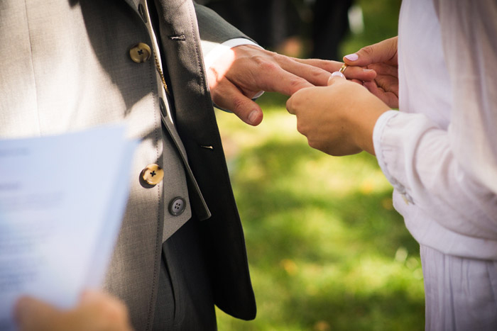 bride putting ring n groom's finger