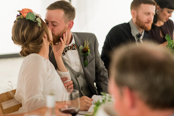 bride and groom kissing at wedding reception