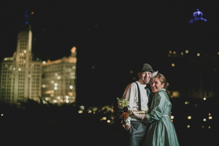 bride and groom in front of night time cityscape