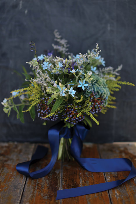 Bó hoa cầm tay xinh xắn với những cánh hoa màu xanh cùng dây buộc màu chàm. 