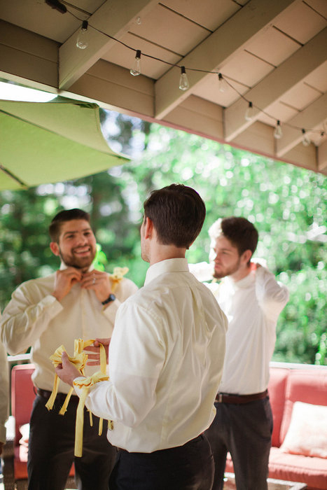 groomsmen putting on bow ties