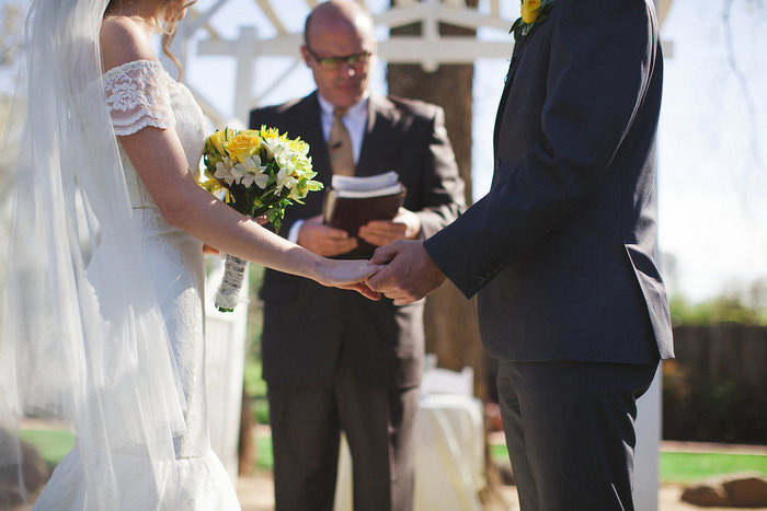 bride and groom holding hands during ceremony