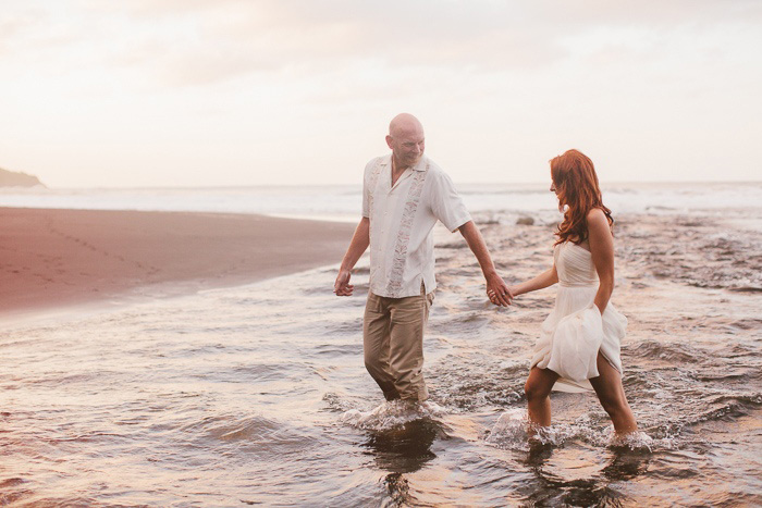 bride and groom walking in the surf