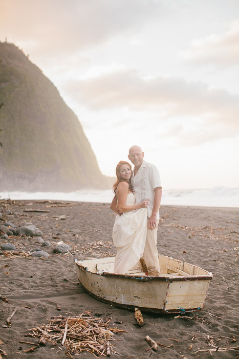 bride and groom standing in a wooden row boat