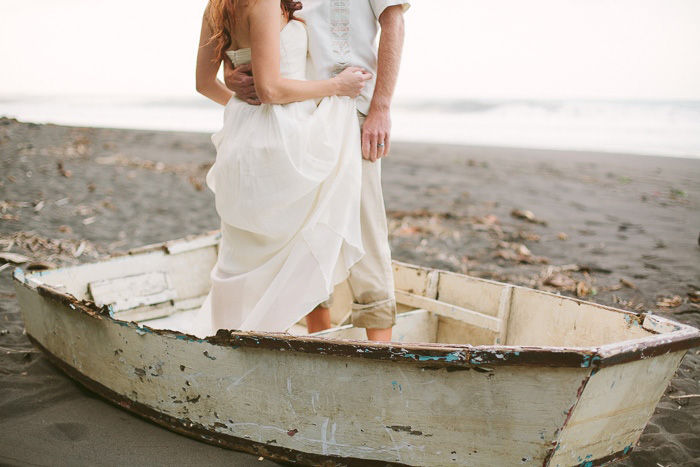 bride and groom standing in wooden boat