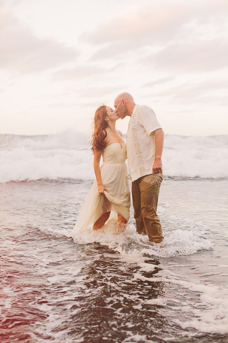 bride and groom kissing in the ocean