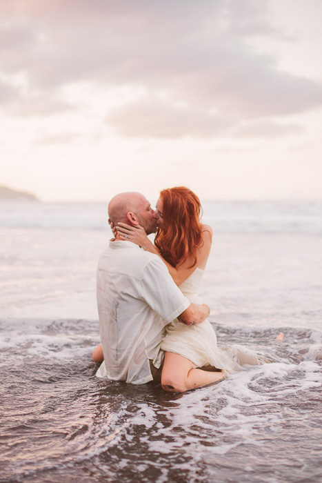 bride and groom frolicking in the surf