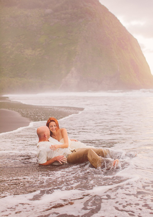 bride and groom lying in the surf