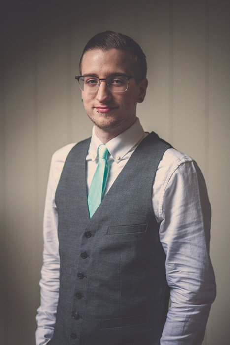 groom in vest and aqua tie