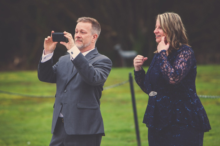 mom and dad taking photos at wedding