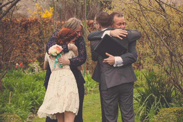 bride and groom hugging parents