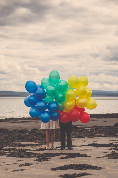 bride and groom on beach with balloons