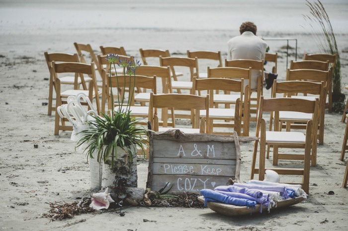 wooden folding chairs set up on the beach for wedding ceremony