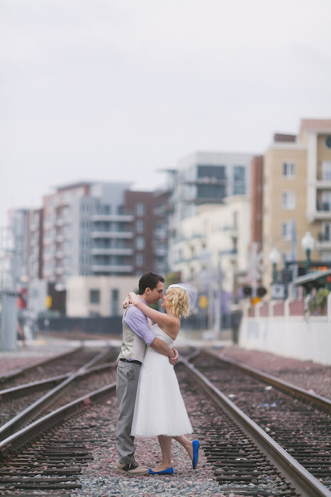 bride and groom kissing on train tracks