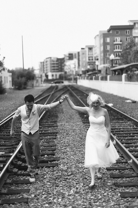 bride and groom walking on train tracks