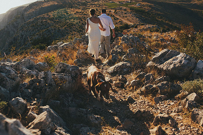 bride and groom walking down cliff