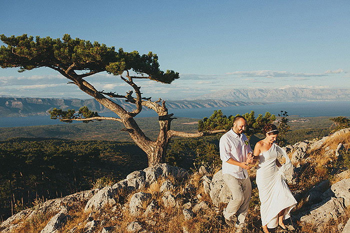 bride and groom walking down cliff