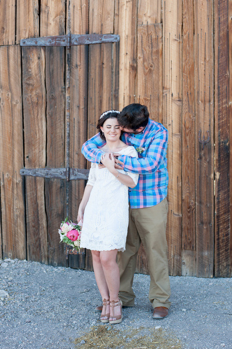 bride and groom in front of barn