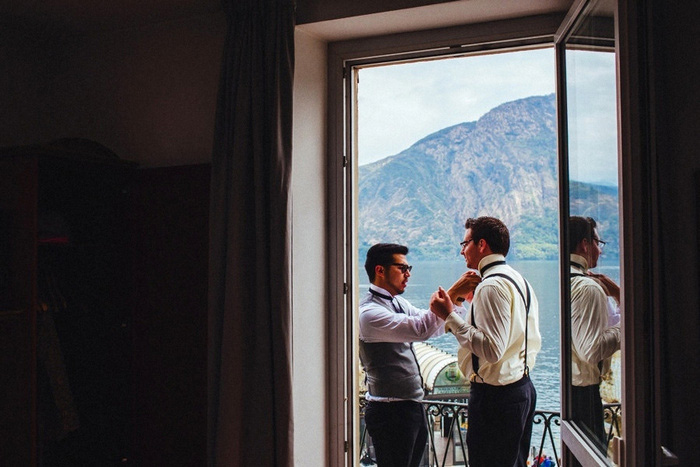 groomsman helping groom with bow tie 