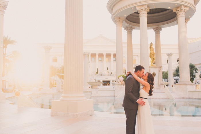 bride and groom kissing by the pool