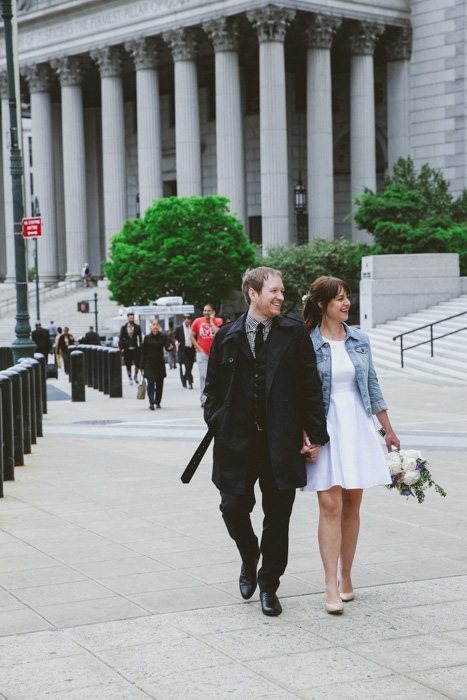 bride and groom strolling outside city hall