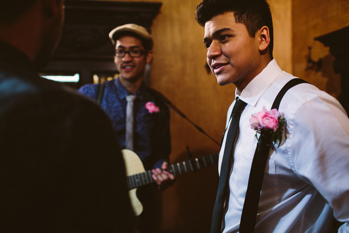 groom in suspenders and pink boutonniere