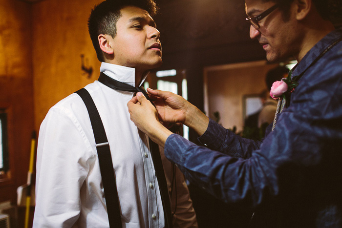 groomsman tying groom's tie