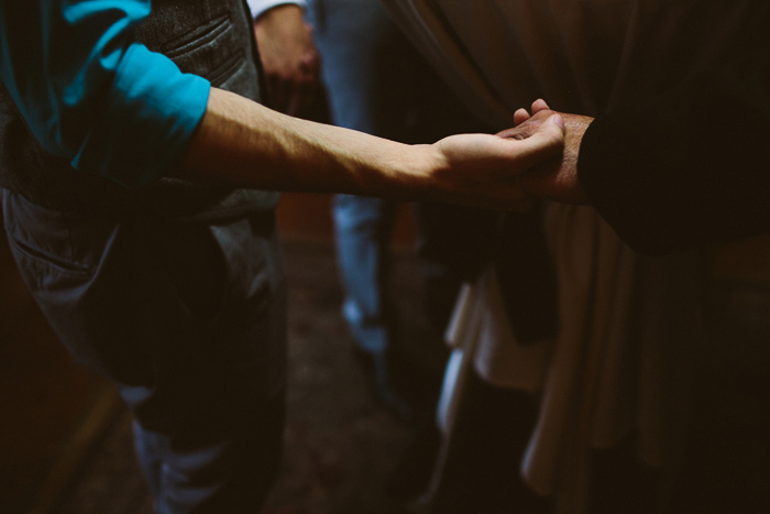 groomsmen holding hands in prayer