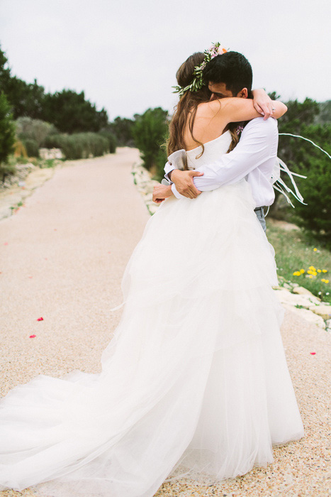 bride and groom hugging on dirt road