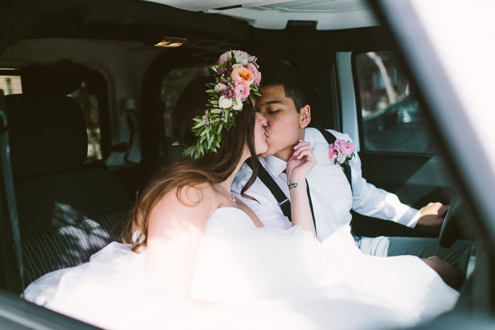 bride and groom kissing in car