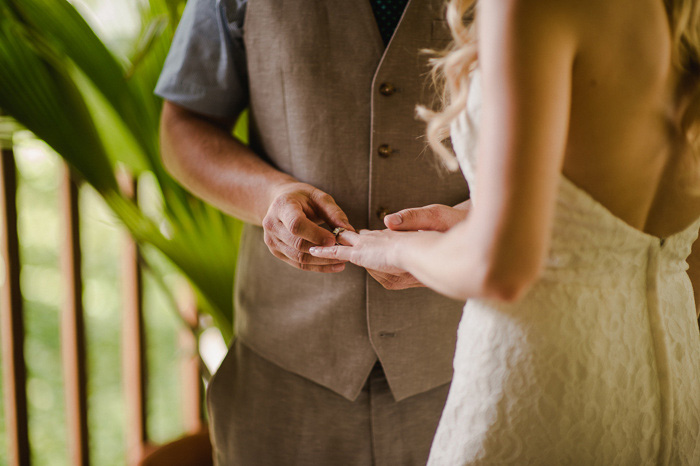 groom putting ring on bride's finger