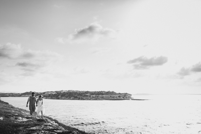 bride and groom walking by the ocean