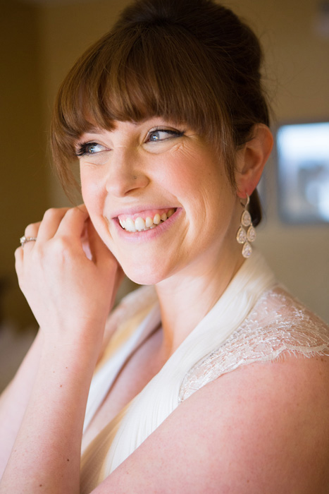 bride putting on earrings