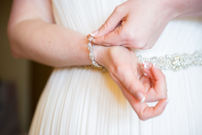 bride putting on bracelet