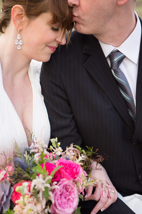 groom kissing bride's forehead