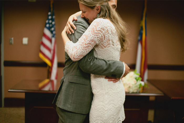 bride and groom hugging in courthouse