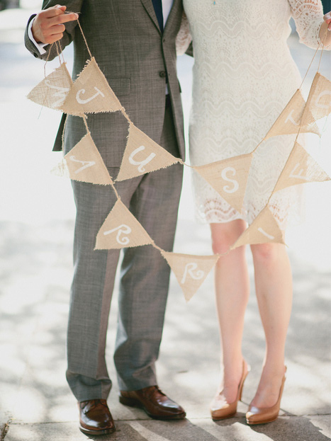 bride and groom with just married bunting