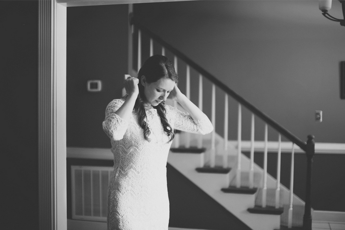 bride putting on necklace