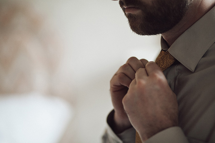 groom adjusting his tie