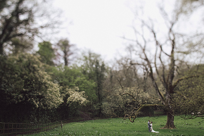 bride and groom walking through irish countryside