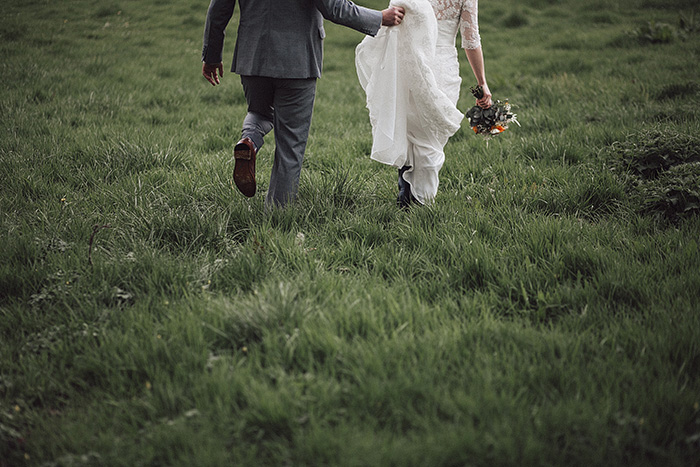 bride and groom walking through irish countryside