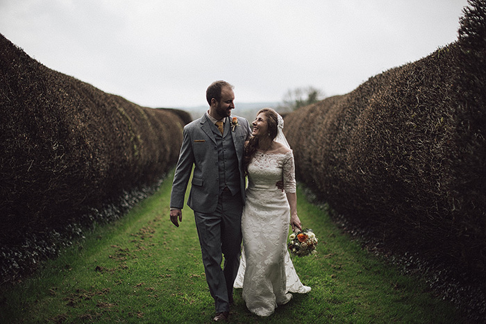 bride and groom strolling on country house grounds