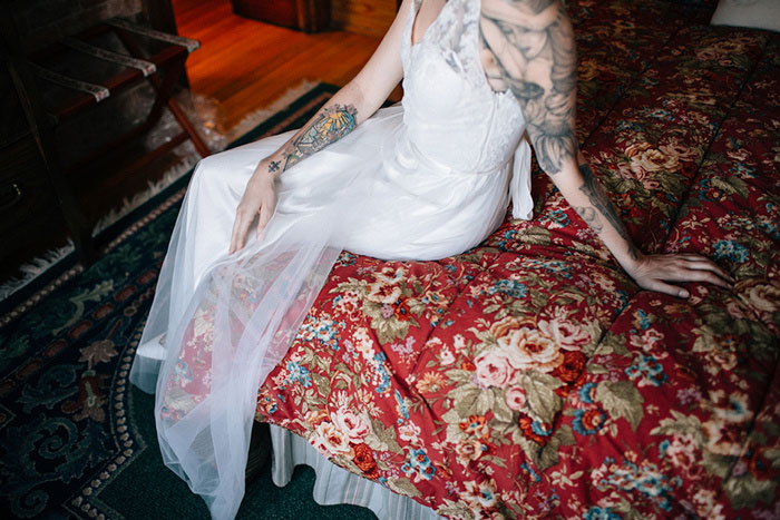 tattooed bride sitting on bed