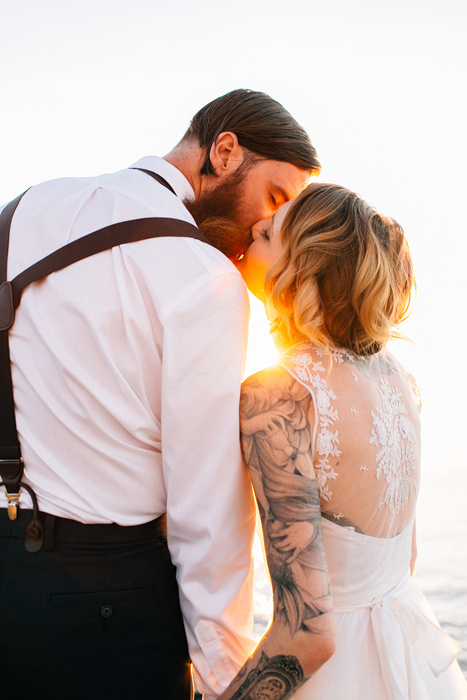 bride and groom kissing at sunset