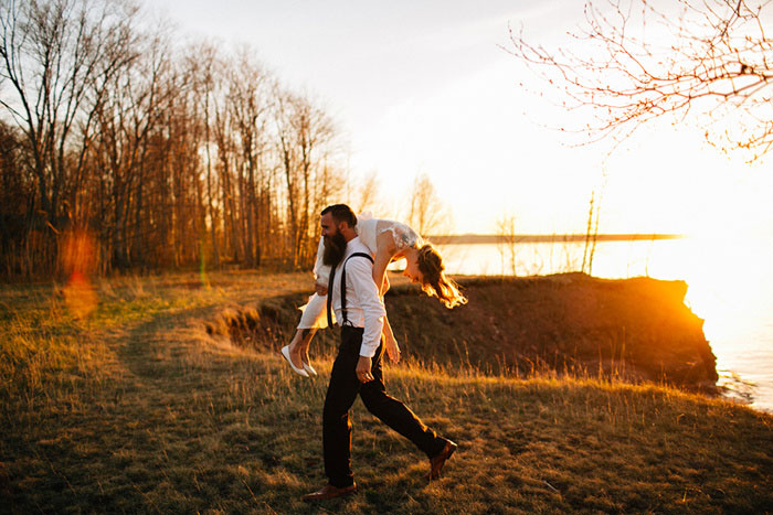 groom carrying bride over his shoulder