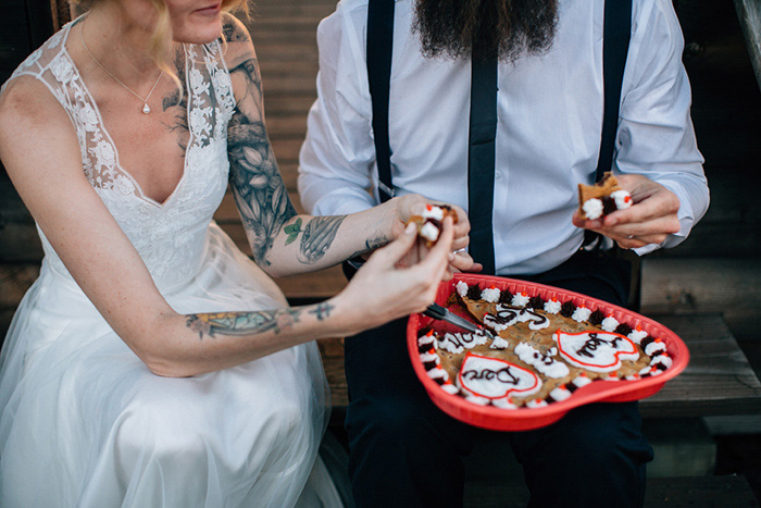 bride and groom sharing heart shaped cookie cake