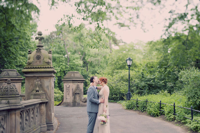 groom kissing bride's forehead in central park