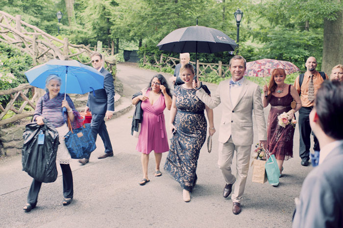 wedding guests walking under umbrellas in Central Park